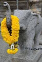 Stone Elephant Sculpture With a Garland of Yellow Flowers in Thailand Journal
