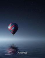 Red and Blue Hot Air Balloon Floating on Air on Body of Water During Night Time